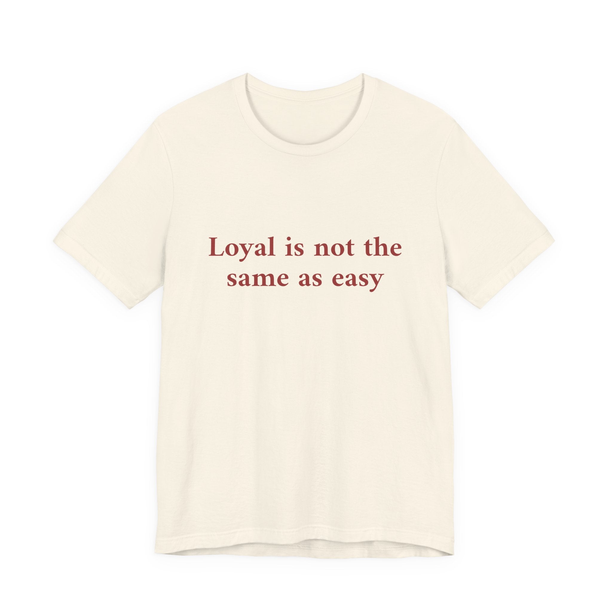 An off-white short-sleeve crewneck t-shirt with the phrase 'Loyal is not the same as easy' printed in a dark red serif font across the chest, displayed on a clean white background.