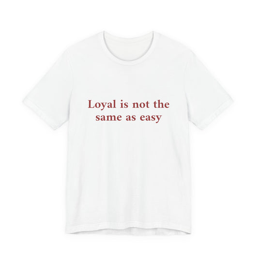 A white short-sleeve crewneck t-shirt with the phrase 'Loyal is not the same as easy' printed in red serif text across the chest, displayed on a clean white background.