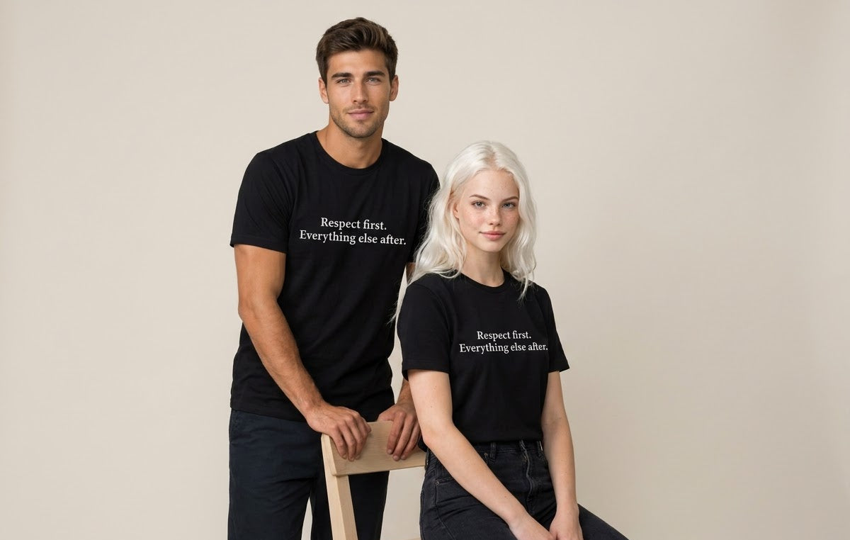 A man and a woman wearing matching black graphic t-shirts with the white printed text 'Respect first. Everything else after.